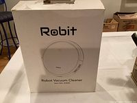 Box of the Robit Robot Vacuum Cleaner showing front view with brand name, image of device, and model number R3000.