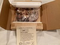 Photo showing the decorative plate wrapped in bubble wrap and secured with foam in the original box, along with the Certificate of Authenticity.