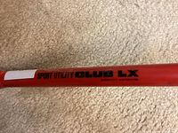 Close-up of the label 'Sport Utility Club LX' on the red metal steering wheel lock.