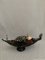 Side view of the black gondola music box with painted gondolier and dancer figurines on top.