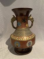 Front view of the vase showing handles and the enamel detailed decorative body.