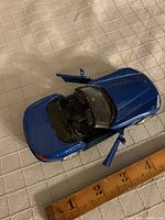 Top view of blue diecast Dodge Viper model with doors open and ruler below showing length approx. 5.5 inches.