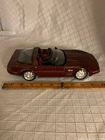 Side view showing maroon 1992 Corvette diecast model with a ruler for size reference.