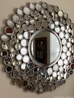Full view of the satin nickel circle wall mirror showing the array of smaller mirrors surrounding the center.