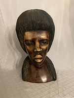 Front view of the hand carved ebony bust showing detailed facial features and texture in hair.