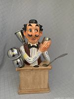 Front view of the mid-century kitschy bartender figurine barware tool holder with three tools displayed.