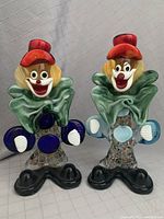 Front view of the pair of glass clown figurines showing colorful features and overall condition.