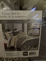 Luxury Bed Set packaging showing styled bed set with comforter, pillow shams, cushions, and bed skirt on double bed.