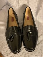 Top view of new black leather tassel loafers showing Bass brand insole and tassel detail