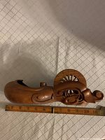 Full side view of hand carved ink pot with spool and decorative scrollwork