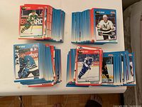 Four piles of assorted 1990-91 Score branded NHL hockey cards showing front player images.