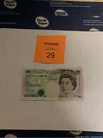 Single Bank of England £5 banknote placed on white background with orange MaxSold lot sticker in photo for identification