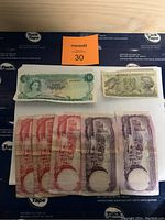 Photo showing a $1 Barbadian note, 100 Lire Italian note, and several Bahamian notes.