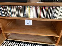 Two rows of classical music CDs in jewel cases on wooden shelves, focusing on Beethoven and Bach compositions