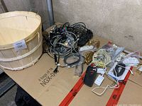 Photo showing assorted black, white, and gold cables tangled together along with a black phone case and white USB adapters.