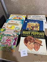 Photo shows all 7 children's record album covers stacked in a box, colorful vintage illustrations visible including Mary Poppins and Oliver! titles.