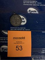 Front side of the coin pendant showing years 1957 and 1982 with a crowned emblem in the center.