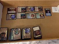 Cards including character and adventure cards with text, icons, and images laid flat in box.