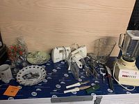 Photo showing the kitchen lot with blender, mixers, glasses, and various plates