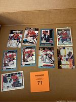 Photo of 9 Patrick Roy hockey cards in a cardboard box with a MaxSold tag visible.