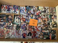 Photo of assorted hockey goalie trading cards spread out on a flat surface inside a box