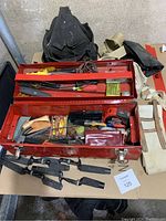 Overview of toolbox with various hand tools and nylon straps placed on table
