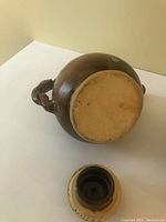 View from bottom side showing ceramic base of tea pot and lid, natural clay color