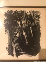 Close-up of the black and white forest scene print showing signature and details of the wooded path with a figure running.