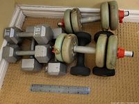 Image showing pairs of metal hex dumbbells in 10 lb, 15 lb, and 20 lb sizes, and a pair of adjustable dumbbells with round plates and red locking collars.