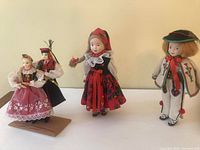 Front view of three dolls showing traditional Polish regional costumes.