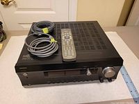 Integra AV receiver top view with remote and speaker cables