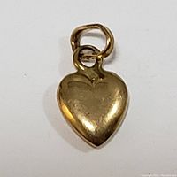 Close-up image of the front of the 18K yellow gold heart-shaped pendant showing the smooth polished surface and heart outline.