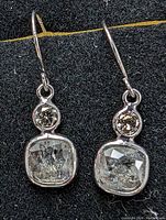 Front view of pair of earrings on black background