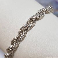 Close-up side view of the sterling silver rope chain bracelet highlighting interwoven links.