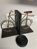 Side angle showing metal bicycle book ends and nested cast iron paperweights in front