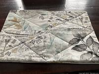 Single placemat showing reversal with vintage French text and floral fabric design.