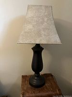 Full view of the tall lamp showing ceramic base and leather-look shade