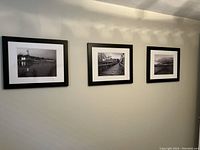 Wide shot of the three black-framed photographic prints hung in a row on a wall