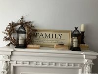 Full mantle arrangement showing all items including Family sign, berry wreath, birdcage candle holders, books, and candles.