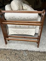Front view of wooden quilt rack showing three horizontal bars and rectangular frame.