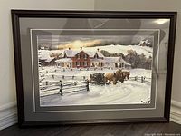 Full view of framed winter scene print showing horses pulling sleigh in snow with brick house and wooden fence background.
