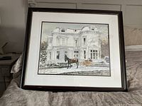 Full view of framed winter print showing a large historic residence with snow and a horse-drawn sleigh outside. The frame is dark wood with gold trim and white mat.