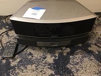 Front view of Wave system main unit on carpet with infrared remote beside it