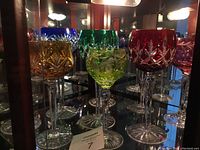 Display case view of nine colored crystal goblets