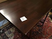 Top surface view of the dark wood rectangular drop leaf table with one drawer.