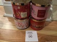 Four Bath and Body Works holiday candles stacked showing fronts of pumpkin apple, crushed candy cane, and two 'Tis the Season candles.