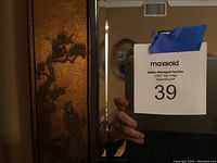 Close-up of the detailed figure and tree on the bronze/gold colored frame with Oriental themes.