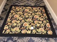 Entire Williamsburg style floral tablecloth laid flat, showing full pattern and border.