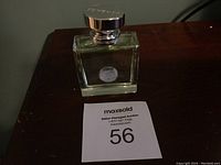 Full view of the Versace Versense Eau De Toilette bottle on a dark surface, showing the bottle shape and intact cap.