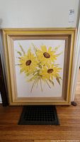 Full view of framed oil painting showing three large yellow sunflowers and green stems against a light background.